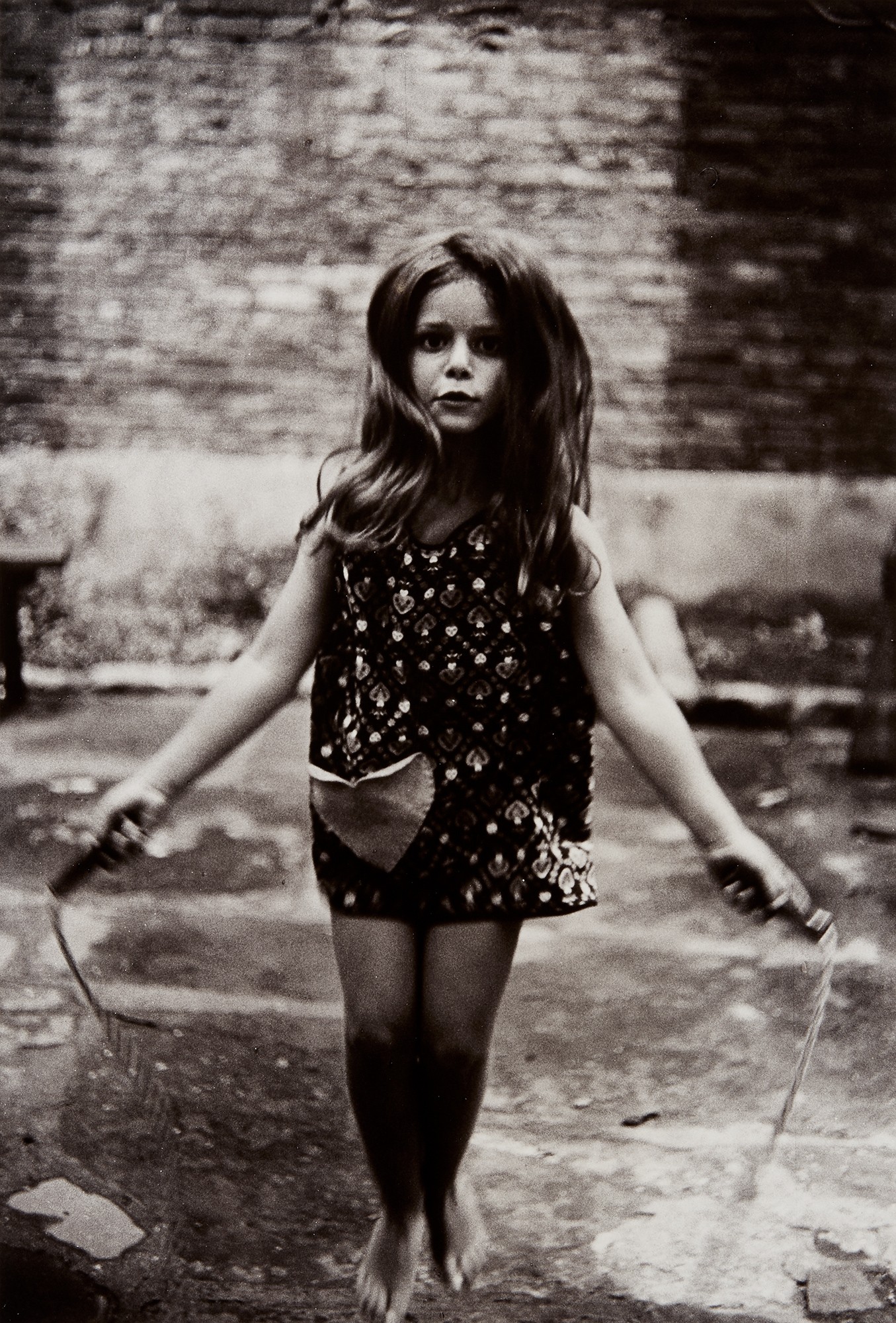 <p><strong>DIANE ARBUS</strong> <em>Barefoot child jumping rope, N.Y.C.</em>, 1963</p>
