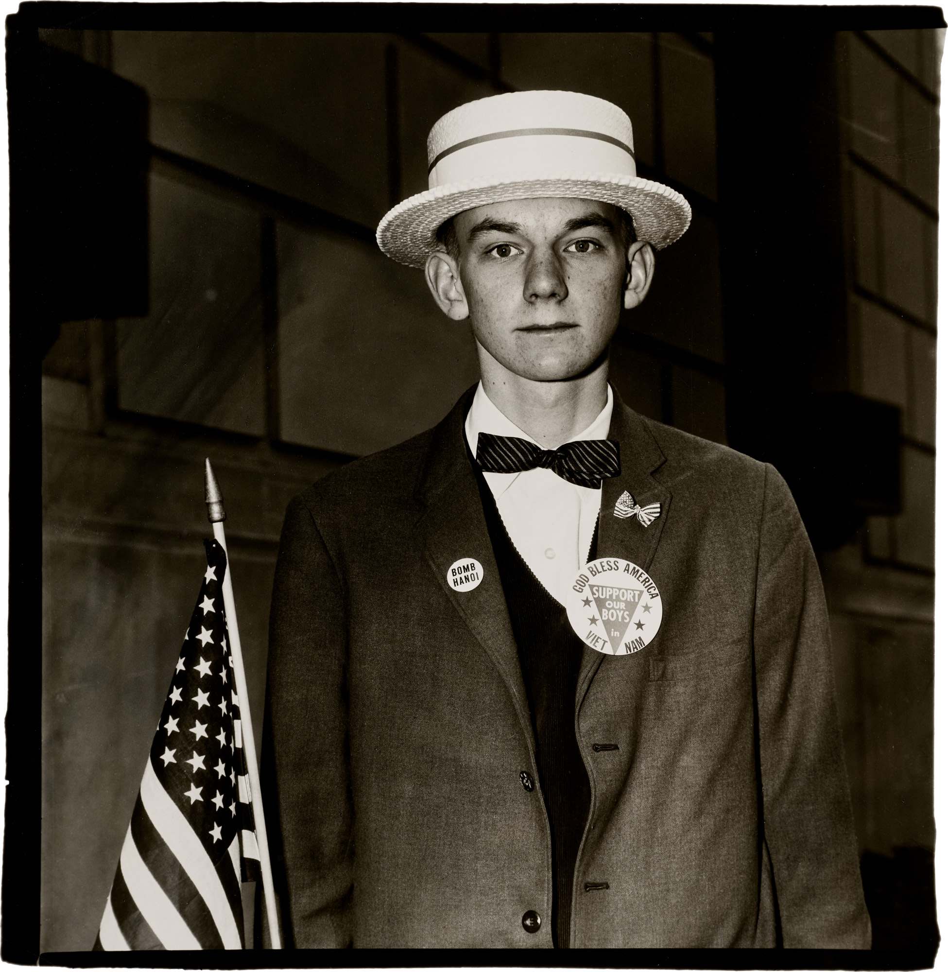<p><strong>DIANE ARBUS</strong> <em>Boy with a straw hat waiting to march in a pro-war parade, N.Y.C.</em>, 1967</p>